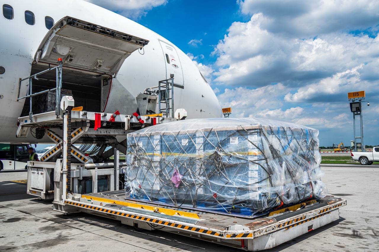 Ein geöffnetes Flugzeug steht auf dem Rollfeld und wird mit Pharma Produkten beladen.